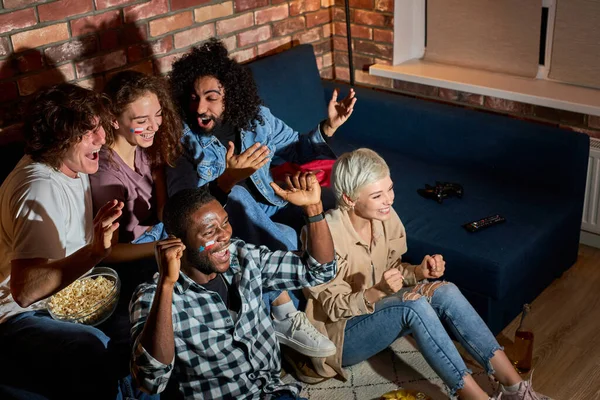 Les jeunes regardent le sport célébrer l'objectif, tout en regardant la compétition à la télévision — Photo