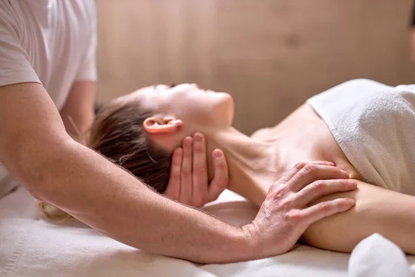 Professionell beskärd terapeut gör hälsosam massage på hals och axlar till kvinnliga klienten — Stockfoto