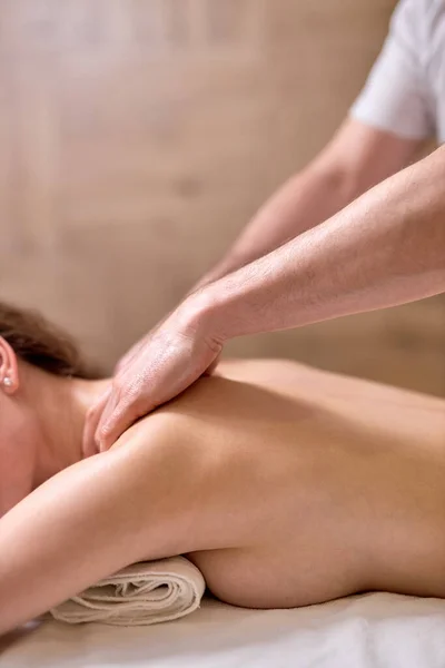 Young female at spa resort, receiving massage on neck and shoulders muscles, close-up — Stock Photo, Image