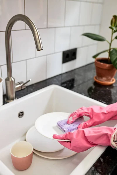 Foto de cerca de las manos femeninas lavándose el plato blanco con esponja y espuma en el fregadero de la cocina —  Fotos de Stock