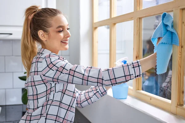 Mujer caucásica limpie el vidrio, vidrio de la ventana de limpieza por la suciedad. limpiar con un paño y esterilizar la solución limpia. —  Fotos de Stock