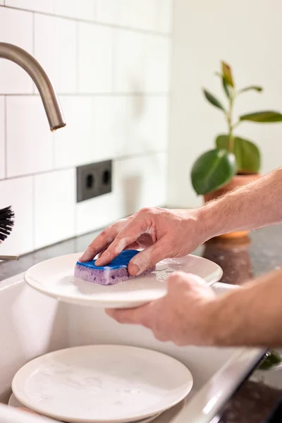 Bijgesneden man afwassen thuis keuken. close-up man handen doen huishouden — Stockfoto