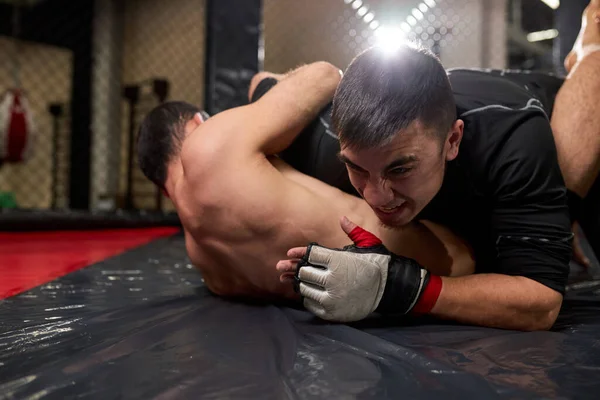 Vista de bajo ángulo de dos luchadores profesionales luchando en el gimnasio. Boxeadores fuertes con cuerpo perfecto luchando — Foto de Stock