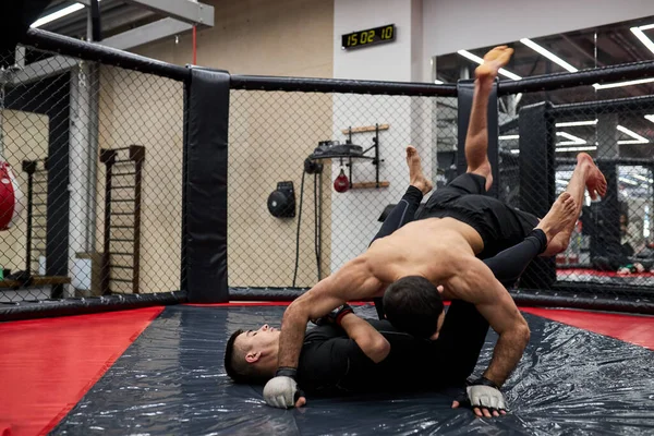 Concepto deportivo de lucha sin reglas. Dos poderosos luchadores fuertes en el gimnasio, entrenando —  Fotos de Stock