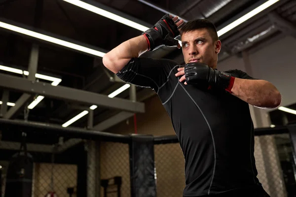 Fit sterke man bokser in handschoenen staande in vechtpose tijdens de training — Stockfoto