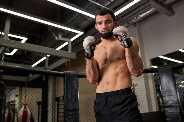 Shirtless säker vuxen manlig boxare stå i pose, utför övningar i ring i gym. boxerträning — Stockfoto