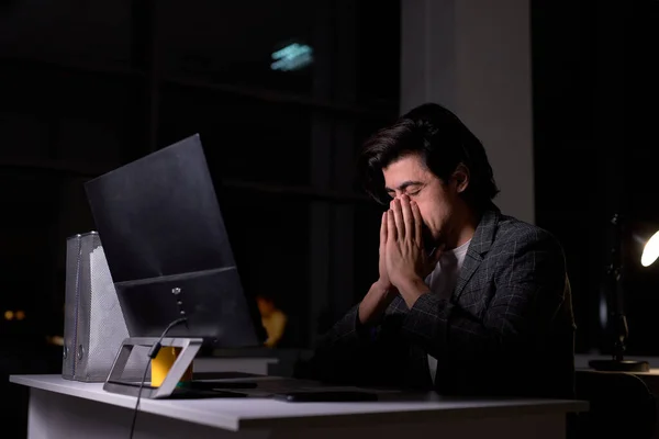 Portrait of tired male in suit sitting at desk in office using computer pc, thinking — Stock Photo, Image