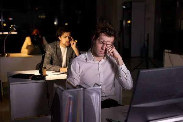 Ogen van jonge mannelijke kantoormedewerker gewond door overinspanning, werken op de computer — Stockfoto