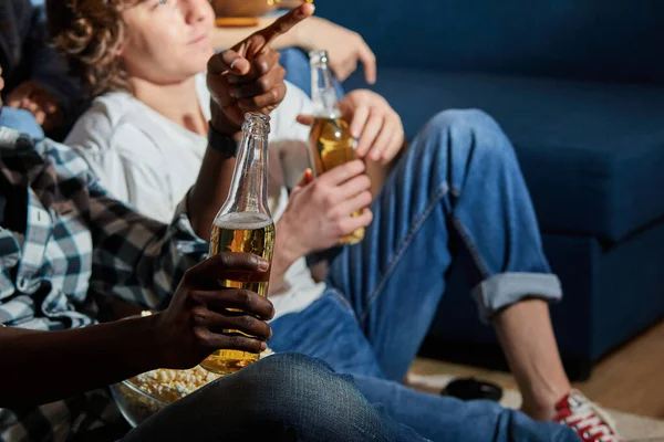 Interracial grupo de amigos comendo pipoca e beber cerveja em casa, gosta de assistir filme — Fotografia de Stock