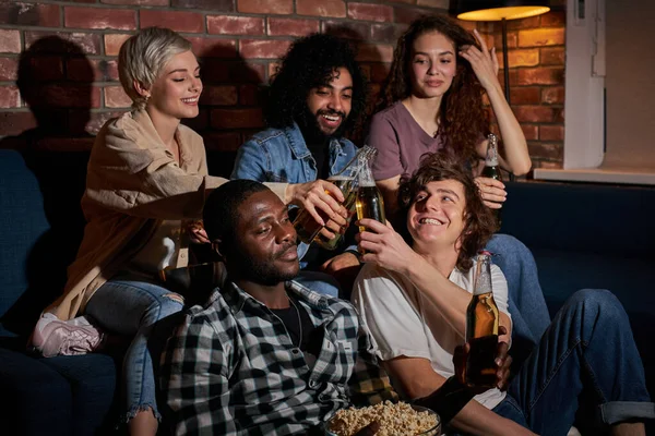 Amigos alegres sentados en casa y viendo partidos de fútbol en la televisión. Su equipo favorito está ganando, concepto de victoria — Foto de Stock