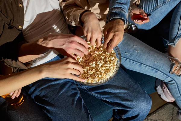 Personas viendo la televisión, programa de comedia o película y comer bocadillos de palomitas de maíz, sentado en el sofá acogedor en casa — Foto de Stock