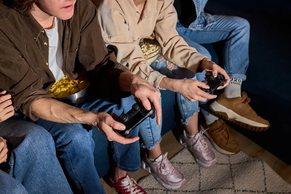 Amis fous de jeunes gens qui aiment jouer à la console de jeu vidéo, reposant à la maison — Photo