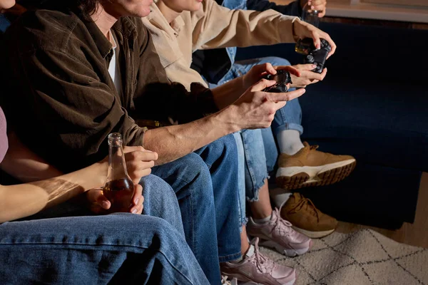 Friends having fun by playing game console at home, indoors. Friendship, leasure, rest, home party concept — стоковое фото