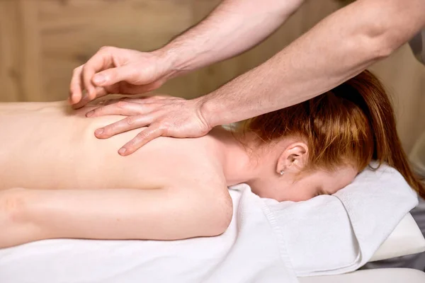 Irriconoscibile rossa femminile ottenere massaggio sulla colonna vertebrale, la cura della pelle, concetto di spa, massaggio, relax. — Foto Stock