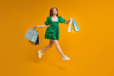 Komik bayan turistin tam vücut fotoğrafı. Alışveriş merkezinde bir sürü çanta taşıyor.