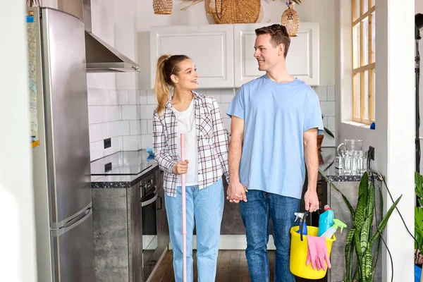 Barátságos házaspár boldog, miután otthon takarítottak, szeretettel néztek egymásra — Stock Fotó