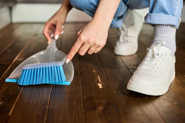 Womans hands sweeping Dust with brush and dustpan, holding broom and sweeping floor, collecting dust into dustpan — Stockfoto