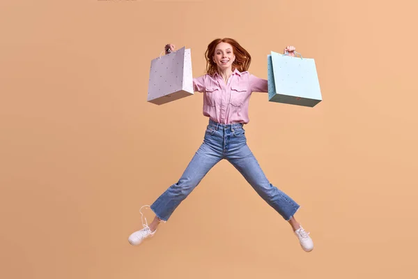 Feliz caucásico pelirroja dama feliz después de ir de compras, llevar paquetes en las manos —  Fotos de Stock