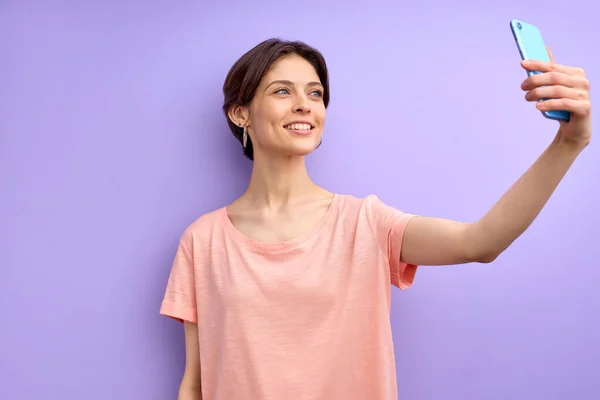 Mujer atractiva con el pelo corto tomar una foto en el teléfono móvil, hacer selfie — Foto de Stock