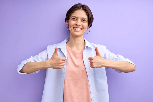 Positiv kvinna i ledig skjorta visar tummen upp framför kameran, poserar — Stockfoto