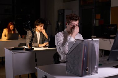 Resmi giyinen genç beyaz adam depresyon ve kronik iş yorgunluğu çekiyor.