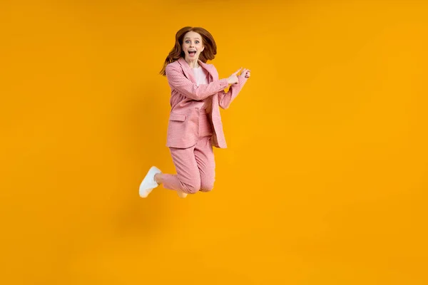 Foto de comprimento total de senhora engraçada em terno rosa saltando para cima ver baixos preços de compras — Fotografia de Stock