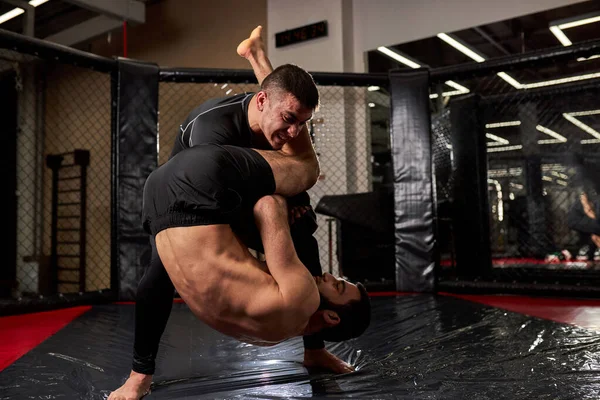 Dois desportistas MMA chão lutando, preparando-se para o Campeonato em artes marciais mistas — Fotografia de Stock