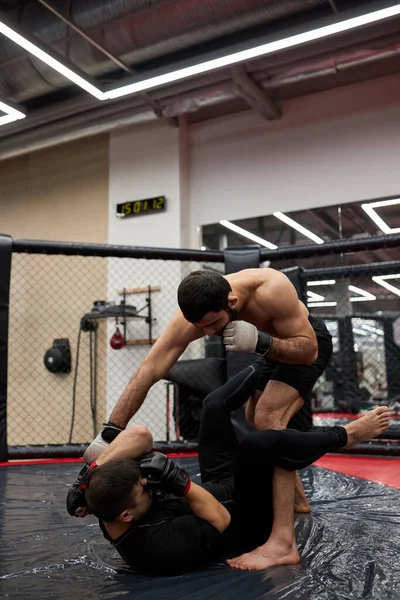 Concepto deportivo de lucha sin reglas. Dos poderosos luchadores fuertes en el gimnasio, entrenando —  Fotos de Stock