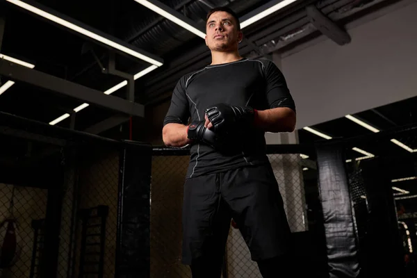 Boxeador masculino fuerte serio en guantes de boxeo está en pose listo para luchar en el ring —  Fotos de Stock