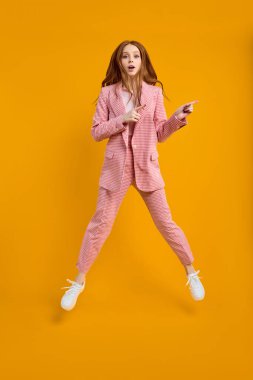 Tam boy vücut ölçüsü, merak uyandıran iş kadını atlama ifadesi.