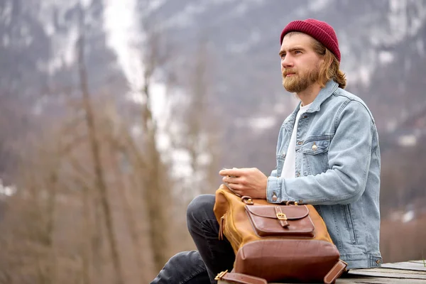 Sidovy på ung kaukasisk man sitter ha vila i bergslandskapet. turist hane — Stockfoto