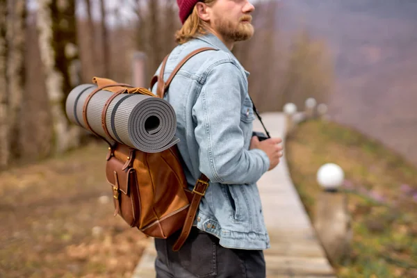 Hipster man med ryggsäck utforska naturen på våren, promenader ensam utomhus — Stockfoto