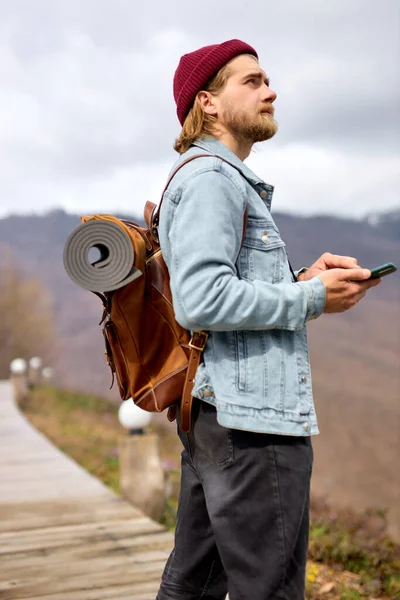 Boční pohled portrét pohledný muž cestovatel pomocí smartphonu, mobilní telefon. cestovní koncept — Stock fotografie