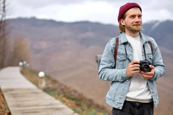 Šťastný vousatý muž turista s kamerou chůze, fotografování, usmívání, dívá se na stranu — Stock fotografie