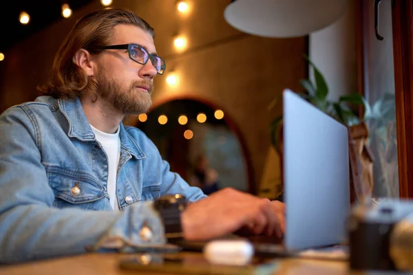 Side View Portret van Handsome Caucasian Guy In Denim Jacket Werken op laptop, Gericht — Stockfoto