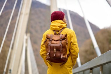 Nehirdeki köprüden geçen adamın arka görüntüsü, açık hava aktivitesi, seyahat konsepti