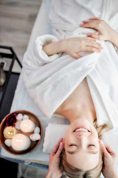 Вид позитивной спокойной женщины, расслабляющейся в то время как осторожный специалист маскирует ее лицо