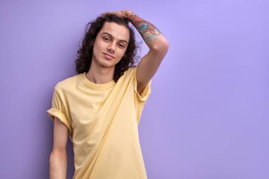 Kıvırcık siyah saçlara dokunan yakışıklı beyaz adamın portresi.