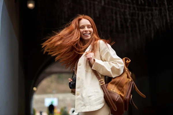 Avslappnad vänlig trendig ung rödhårig kvinna med varmt leende promenader, njuter — Stockfoto