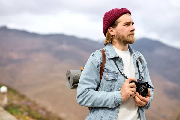 Cestovatel procházky v horách s kamerou, těší scenérie, boční pohled portrét — Stock fotografie