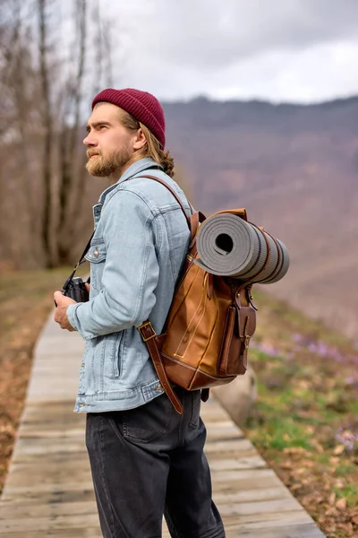 Ung man med ryggsäck utforska naturen på våren, promenader ensam utomhus — Stockfoto