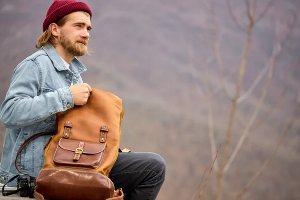 Turist man öppna läder brun ryggsäck under vandring i bergen, sidovy — Stockfoto