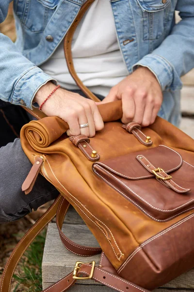 Man tar läder brun handgjorda ryggsäck på promenad, närbild foto. — Stockfoto