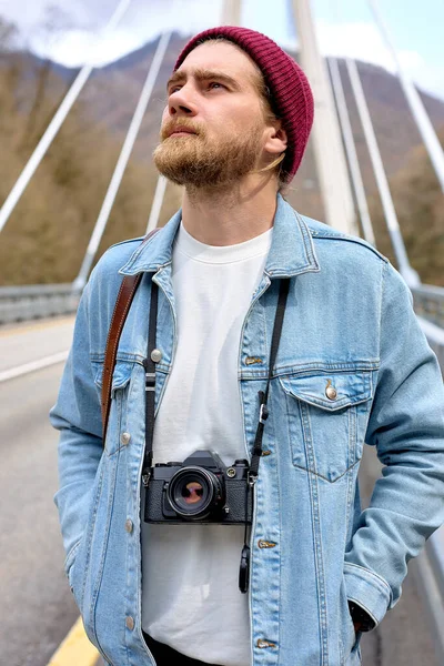 Mladý kavkazský fotograf, cestuje sám s kamerou. Na mostě — Stock fotografie