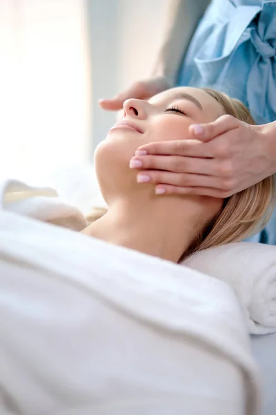 Een vrouw die ontspannende gezichtsmassage doet in de salon. Klassieke massage voor doelgerichte preventie. — Stockfoto