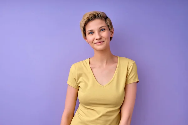 Verlegen volwassen vrouw met kort haar in casual dragen poseren glimlachen op camera — Stockfoto