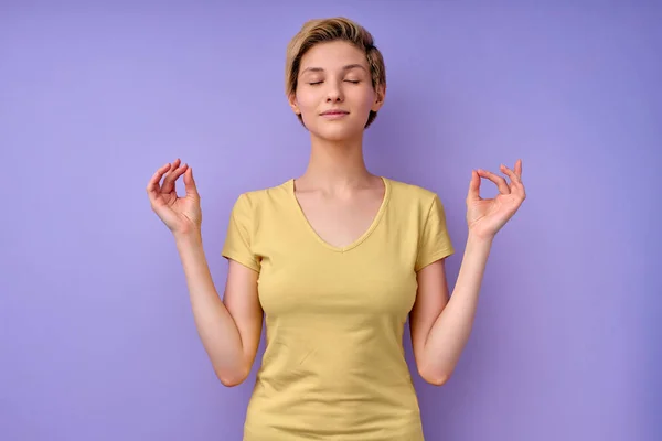 Adult female in casual wear keep calm, meditating with eyes closed in studio — Stock Photo, Image