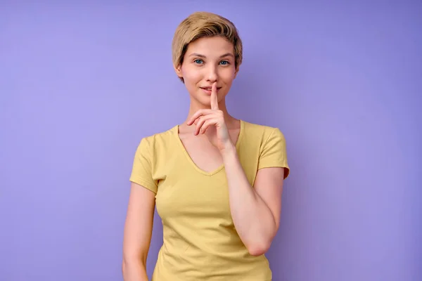 Jovem caucasiana mantendo o dedo na boca pedindo para ficar quieta, manter o silêncio — Fotografia de Stock