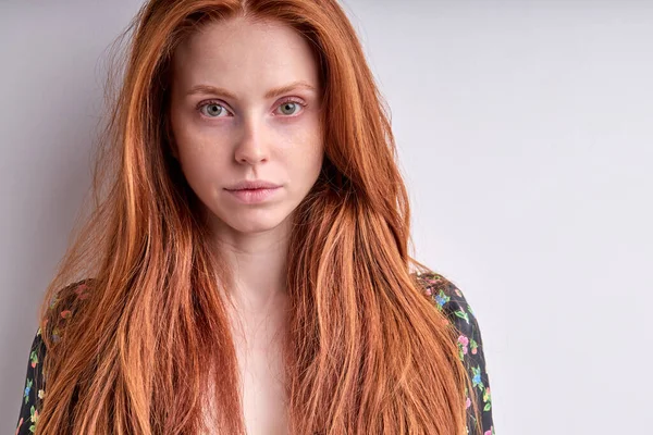 Közelkép egy fiatal, vörös hajú nőről, aki magabiztosan, elszigetelten néz a kamerába. — Stock Fotó