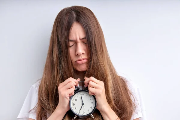 Young lady with alarm clock awakening hard early wearing casual white t-shirt isolated — Stock Photo, Image